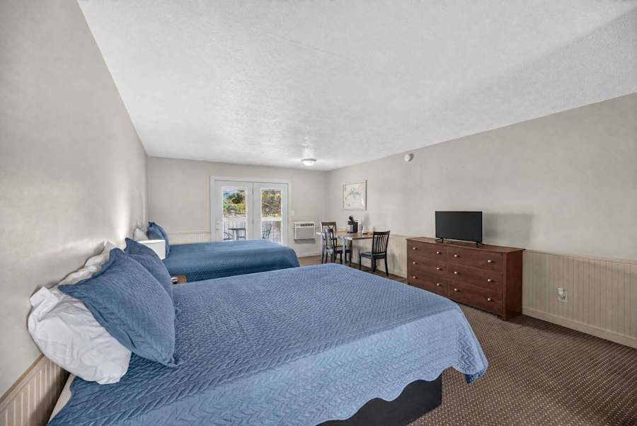 Coffee maker, TV, dresser, two queen beds, & table with chairs